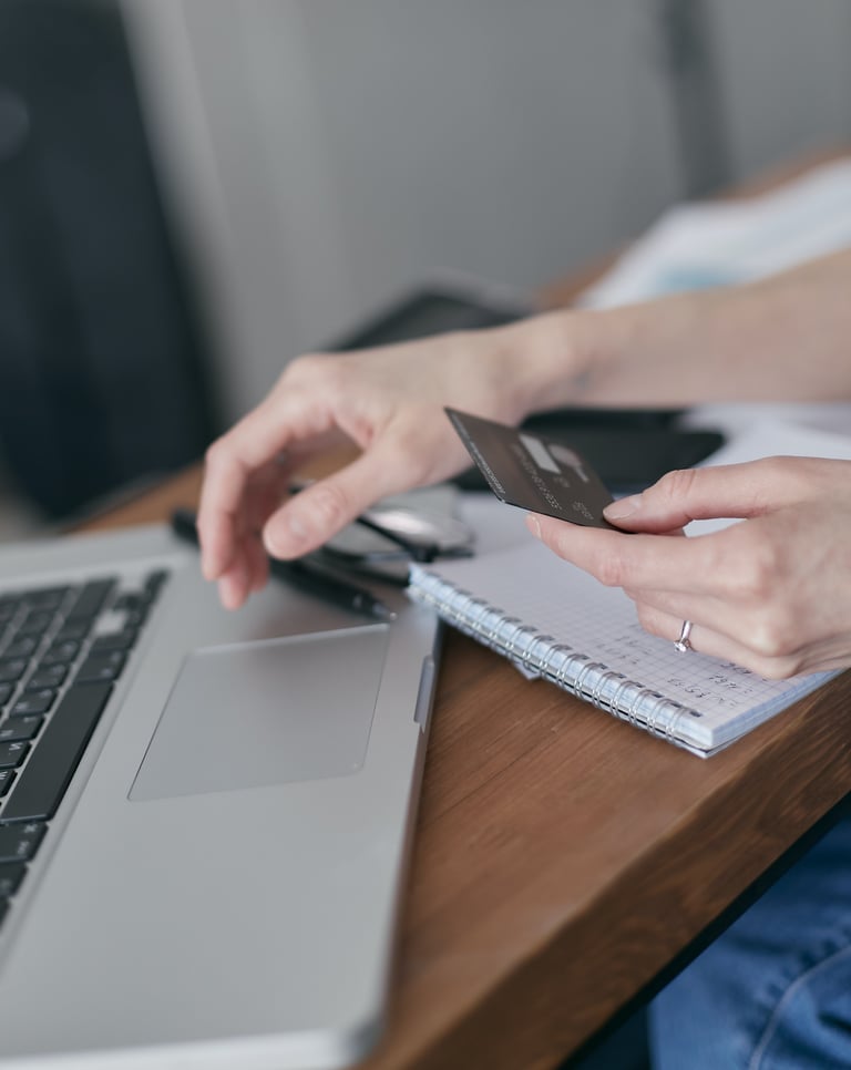 mão de uma mulher, segurando cartão de crédito e usando o gateway de pagamento iugu